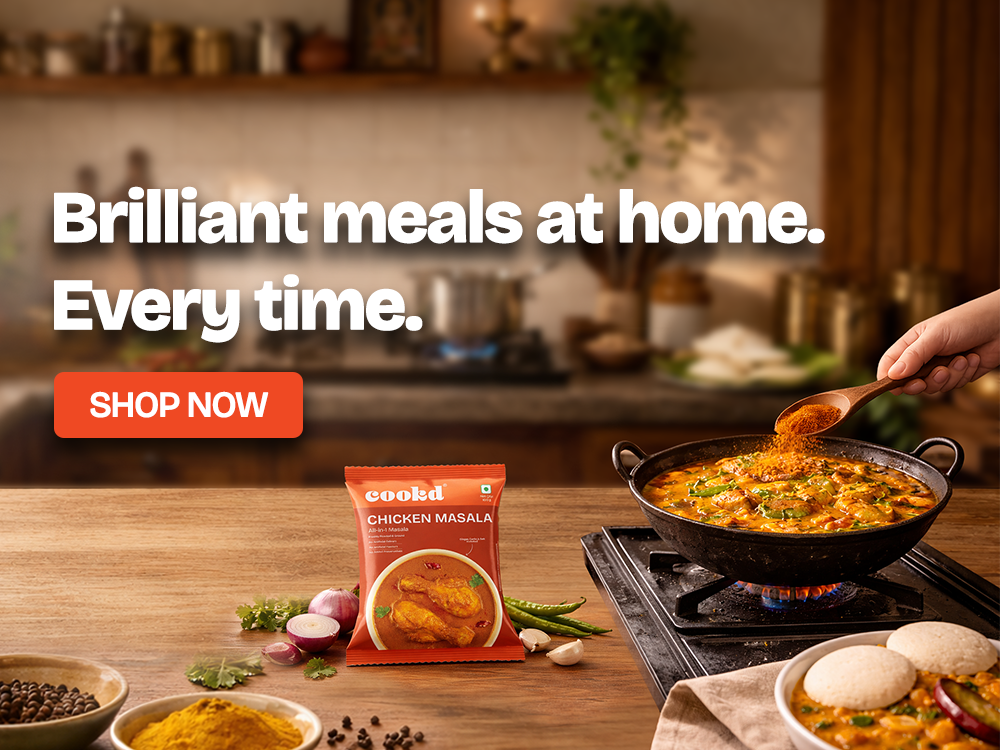 Cooked chicken masala package with a pan of food on a stove, kitchen background.